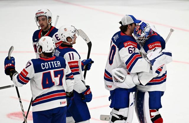 USA's goalkeeper #1 Devin Cooley (R) is comforted by USA's goalkeeper #60 Joseph Woll after the IIHF Ice Hockey Men's World Championship quarter-final match between Canada and USA in Fribourg, Switzerland on May 28, 2026. (Photo by Fabrice COFFRINI / AFP)