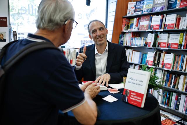 Place publique's centre-left party leader and France's MEP Raphael Glucksmann signs copies of his newly released book titled "Nous Avons Encore Envie" (We still want to) during a book-signing session at the Eyrolles publisher bookshop in Paris on May 28, 2026. (Photo by SIMON WOHLFAHRT / AFP)