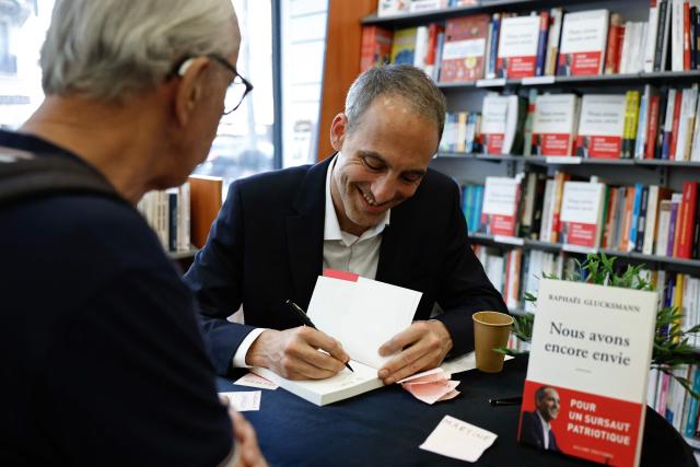 Place publique's centre-left party leader and France's MEP Raphael Glucksmann signs copies of his newly released book titled "Nous Avons Encore Envie" (We still want to) during a book-signing session at the Eyrolles publisher bookshop in Paris on May 28, 2026. (Photo by SIMON WOHLFAHRT / AFP)