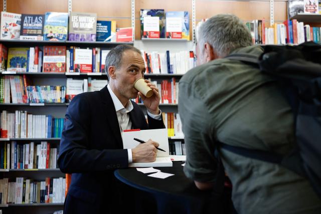 Place publique's centre-left party leader and France's MEP Raphael Glucksmann signs copies of his newly released book titled "Nous Avons Encore Envie" (We still want to) during a book-signing session at the Eyrolles publisher bookshop in Paris on May 28, 2026. (Photo by SIMON WOHLFAHRT / AFP)