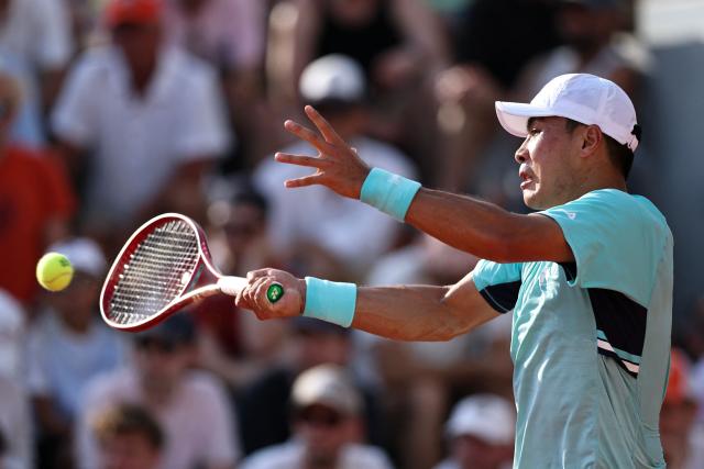 US Brandon Nakashima plays a forehand return to France's Luca Van Assche during their men's singles match on day 5 of the French Open tennis tournament at the Roland-Garros Complex in Paris on May 28, 2026. (Photo by Anne-Christine POUJOULAT / AFP)
