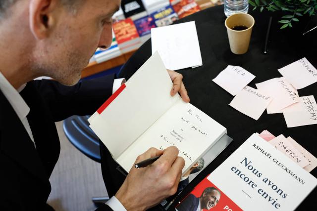 Place publique's centre-left party leader and France's MEP Raphael Glucksmann signs copies of his newly released book titled "Nous Avons Encore Envie" (We still want to) during a book-signing session at the Eyrolles publisher bookshop in Paris on May 28, 2026. (Photo by SIMON WOHLFAHRT / AFP)