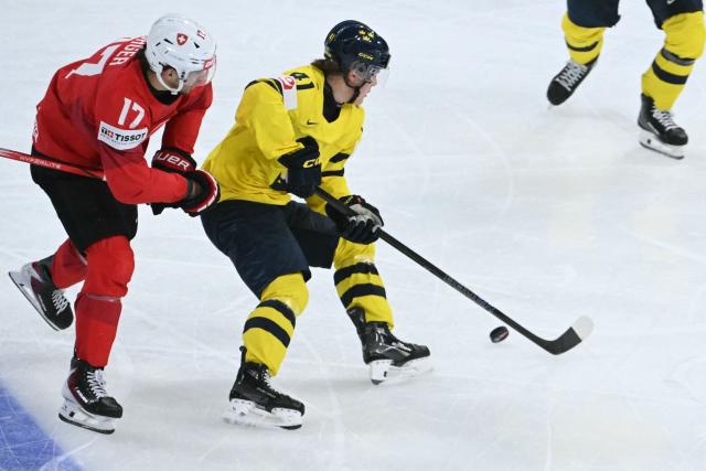 Switzerland's forward #17 Ken Jager (L) fight for the puck with Sweden's forward #41 Ivar Stenberg during the IIHF Ice Hockey Men's World Championship quarter-final match between Switzerland and Sweden at the Swiss Life Arena in Zurich, on May 28, 2026. (Photo by SEBASTIEN BOZON / AFP)