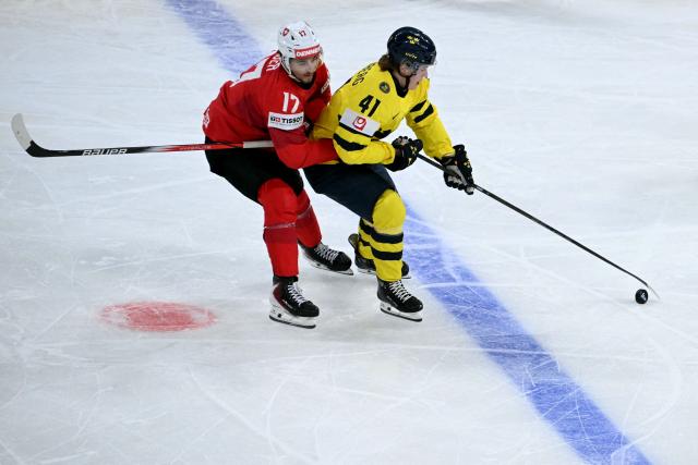 Switzerland's forward #17 Ken Jager (L) fight for the puck with Sweden's forward #41 Ivar Stenberg during the IIHF Ice Hockey Men's World Championship quarter-final match between Switzerland and Sweden at the Swiss Life Arena in Zurich, on May 28, 2026. (Photo by SEBASTIEN BOZON / AFP)