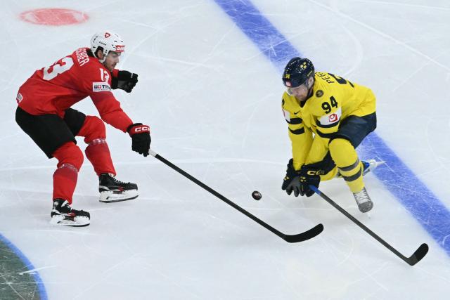 Switzerland's forward #13 Nico Hischier (L) fights for the puck with Sweden's defender #94 Joel Perssonduring the IIHF Ice Hockey Men's World Championship quarter-final match between Switzerland and Sweden at the Swiss Life Arena in Zurich, on May 28, 2026. (Photo by SEBASTIEN BOZON / AFP)