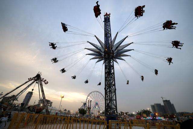 People sit in a ride at an amusement park in the Mansour district of Baghdad on May 28, 2026 on the second day of Eid al-Adha, the Feast of Sacrifice, which marks the end of the annual Hajj pilgrimage to Mecca and commemorates the Prophet Abraham's willingness to sacrifice his son in obedience to God. (Photo by AHMAD AL-RUBAYE / AFP)