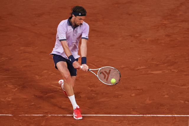 France's Arthur Rinderknech plays a backhand return to Italy's Matteo Berrettini during their men's singles match on day 5 of the French Open tennis tournament on Court Philippe-Chatrier at the Roland-Garros Complex in Paris on May 28, 2026. (Photo by Anne-Christine POUJOULAT / AFP)