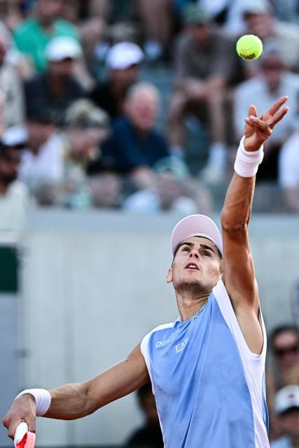 Italy's Matteo Arnaldi serves to Greece's Stefanos Tsitsipas during their men's singles match on day 5 of the French Open tennis tournament at the Roland-Garros Complex in Paris on May 28, 2026. (Photo by JULIEN DE ROSA / AFP)