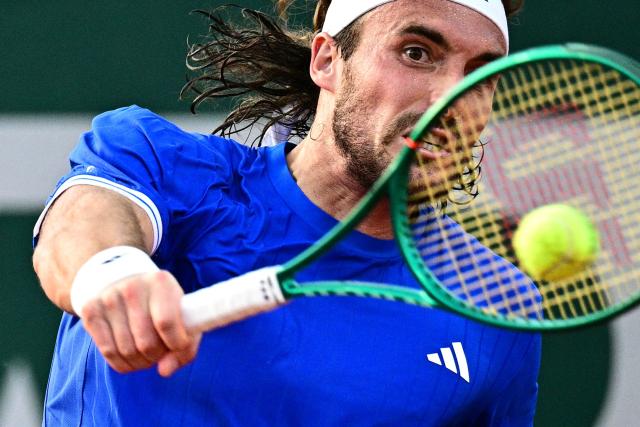 Greece's Stefanos Tsitsipas plays a backhand return to Italy's Matteo Arnaldi during their men's singles match on day 5 of the French Open tennis tournament at the Roland-Garros Complex in Paris on May 28, 2026. (Photo by JULIEN DE ROSA / AFP)