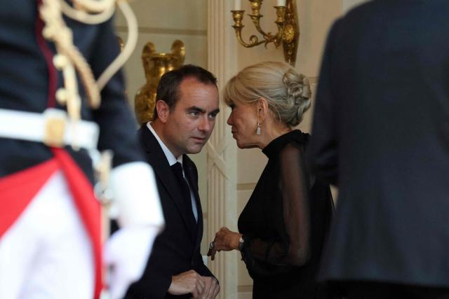 France's Prime Minister Sebastien Lecornu (L) reacts as he speaks with France's first lady Brigitte Macron ahead of a state dinner as part of Indonesia's President's visit at The Elysee Presidential Palace in Paris on May 28, 2026. (Photo by Ludovic MARIN / AFP)