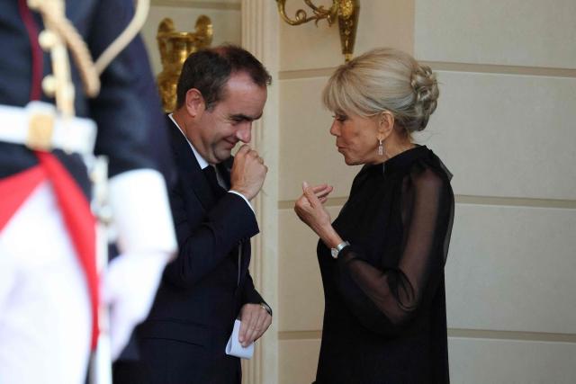 France's Prime Minister Sebastien Lecornu (L) reacts as he speaks with France's first lady Brigitte Macron ahead of a state dinner as part of Indonesia's President's visit at The Elysee Presidential Palace in Paris on May 28, 2026. (Photo by Ludovic MARIN / AFP)