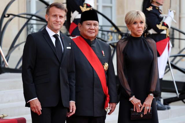 France's President Emmanuel Macron (L) and France's first lady Brigitte Macron (R) weclome Indonesia's President Prabowo Subianto ahead of a state dinner as part of Indonesia's President's visit at The Elysee Presidential Palace in Paris on May 28, 2026. (Photo by Ludovic MARIN / AFP)