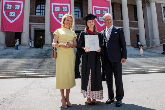 This photo taken on May 27, 2026 shows Princess Elisabeth of Belgium posing in her cap and gown and holding her diploma next to her parents King Philippe and Queen Mathilde at Harvard Yard at Harvard University in Cambridge, Massachusetts. Princess Elisabeth, the heir apparent to the Belgian throne, is graduating with a Master's degree in Public Policy from Harvard Kennedy School. (Photo by Joseph Prezioso / AFP)