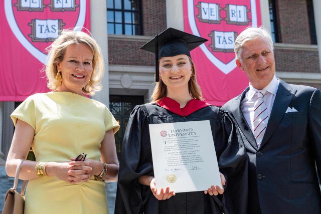 This photo taken on May 27, 2026 shows Princess Elisabeth of Belgium posing in her cap and gown and holding her diploma next to her parents King Philippe and Queen Mathilde at Harvard Yard at Harvard University in Cambridge, Massachusetts. Princess Elisabeth, the heir apparent to the Belgian throne, is graduating with a Master's degree in Public Policy from Harvard Kennedy School. (Photo by Joseph Prezioso / AFP)