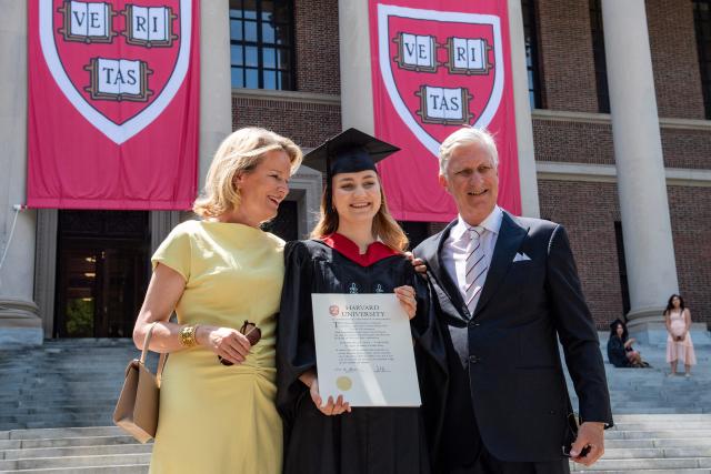 This photo taken on May 27, 2026 shows Princess Elisabeth of Belgium posing in her cap and gown and holding her diploma next to her parents King Philippe and Queen Mathilde at Harvard Yard at Harvard University in Cambridge, Massachusetts. Princess Elisabeth, the heir apparent to the Belgian throne, is graduating with a Master's degree in Public Policy from Harvard Kennedy School. (Photo by Joseph Prezioso / AFP)