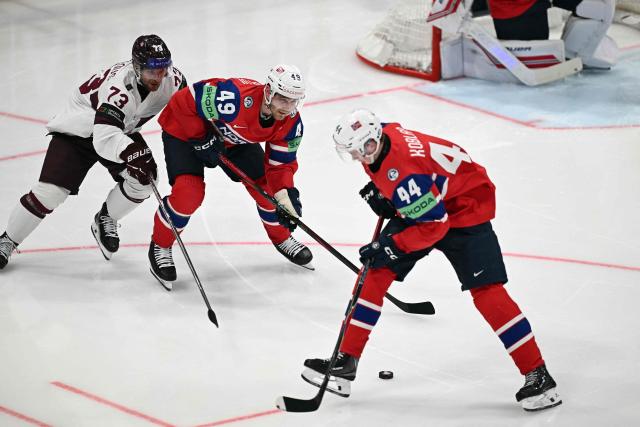 Latvia's forward #73 Deniss Smirnovs (L) vies for the puck with Norway's defender #49 Christian Kaasastul (C) and Norway's forward #44 Tinus Luc Koblar during the IIHF Ice Hockey Men's World Championship quarter-final match between Norway and Latvia in Fribourg, Switzerland on May 28, 2026. (Photo by Fabrice COFFRINI / AFP)