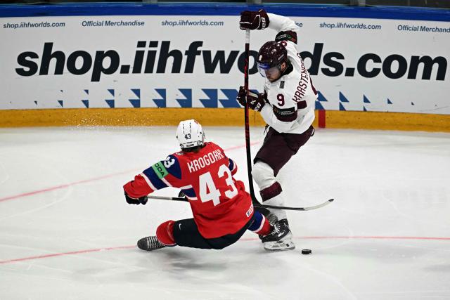 Latvia's forward #09 Renars Krastenbergs (R) and Norway's defender #43 Max Krogdahl crash as they vie for the puck during the IIHF Ice Hockey Men's World Championship quarter-final match between Norway and Latvia in Fribourg, Switzerland on May 28, 2026. (Photo by Fabrice COFFRINI / AFP)