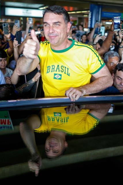 Brazilian Senator Flavio Bolsonaro greets supporters upon his arrival from the US at the International Airport in Brasilia, on May 28, 2026. (Photo by Sergio Lima / AFP)