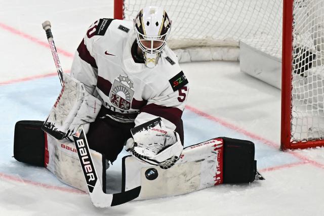 Latvia's goalkeeper #50 Kristers Gudlevskis tries to save the puck during the IIHF Ice Hockey Men's World Championship quarter-final match between Norway and Latvia in Fribourg, Switzerland on May 28, 2026. (Photo by Fabrice COFFRINI / AFP)