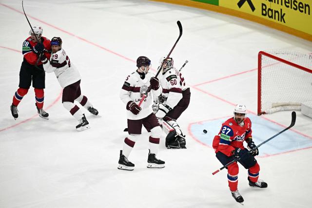 Norway's forward #27 Andreas Martinsen (R) and Norway's forward #28 Michael Brandsegg-Nygard celebrate their team's first goal scored by Norway's forward #44 Tinus Luc Koblar (not pictured) against Latvia's goalkeeper #50 Kristers Gudlevskis (2R) during the IIHF Ice Hockey Men's World Championship quarter-final match between Norway and Latvia in Fribourg, Switzerland on May 28, 2026. (Photo by Fabrice COFFRINI / AFP)