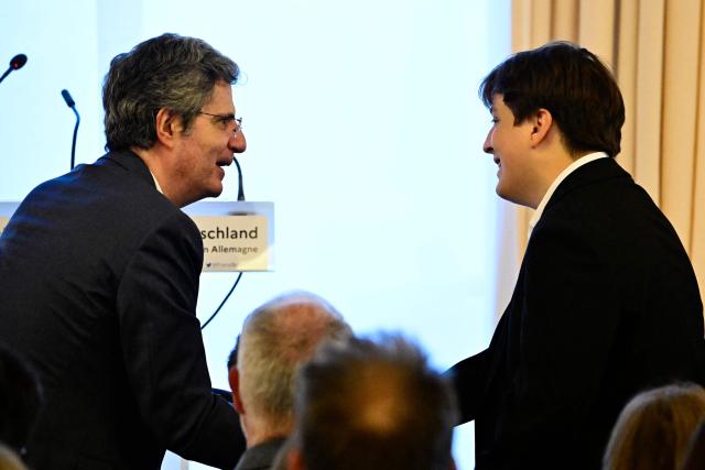 France's ambassador to Germany Franзois Delattre (L) and Matis Bloch, the great-grandson of French historian Marc Bloch shake hands at a ceremony at the French embassy in Berlin, during which three German cultural institutions hand over seven books to the descendants of Marc Bloch (1886–1944) and his wife Simonne Vidal (1894–1944), on May 28, 2026. Marc Bloch, a member of the Resistance, was executed by the Gestapo on June 16, 1944. The restitution of the books was organized by the Berlin State Library – Prussian Cultural Heritage, with the support of the French Commission for the Restitution of Cultural Property and Compensation for the Victims of Anti-Semitic Expropriations (CIVS). (Photo by Tobias SCHWARZ / AFP)