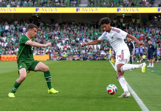 Qatar's Defender #14 Homam El Amin runs with the ball whilst under pressure from Republic of Ireland's defender Seamus Coleman during the international friendly football match between the Republic of Ireland and Qatar, at the Aviva Stadium in Dublin, Ireland on May 28, 2026. (Photo by Paul Faith / AFP)
