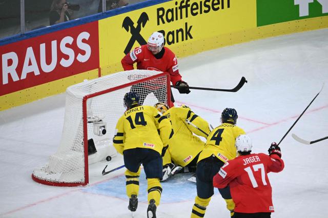 Switzerland's forward #79 Calvin Thurkauf (top) scores his team's third goal during the IIHF Ice Hockey Men's World Championship quarter-final match between Switzerland and Sweden at the Swiss Life Arena in Zurich, on May 28, 2026. (Photo by SEBASTIEN BOZON / AFP)