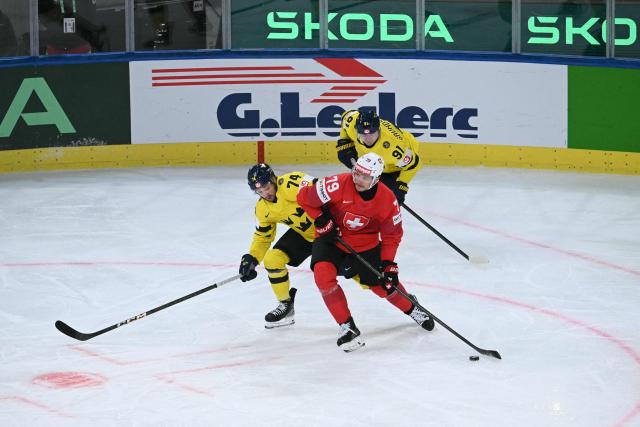 Sweden's forward #74 Rasmus Asplund (L) fights for the puck with Switzerland's forward #79 Calvin Thurkauf during the IIHF Ice Hockey Men's World Championship quarter-final match between Switzerland and Sweden at the Swiss Life Arena in Zurich, on May 28, 2026. (Photo by SEBASTIEN BOZON / AFP)