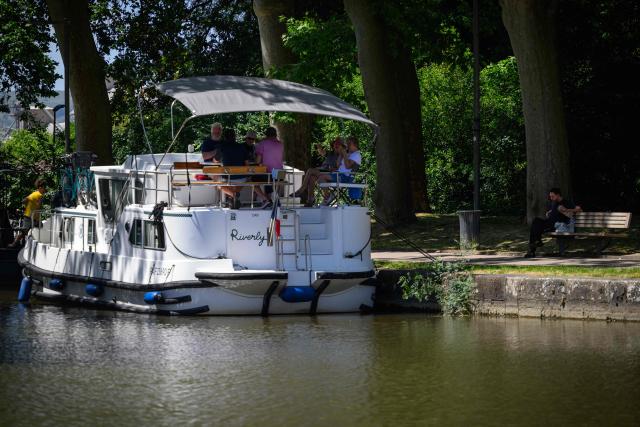 Boats are moored in the port of Castelnaudary on the Canal du midi in southwestern France on May 28, 2026. The 240-kilometre waterway linking Toulouse to the Mediterranean, built in the 17th century and listed as a UNESCO World Heritage Site on December 7, 1996, is marking its 30th anniversary of inscription this year with more than 200 events planned along its banks, even as it faces growing threats from climate change. (Photo by Lionel BONAVENTURE / AFP)