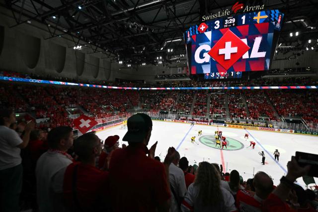 Spectators cheer after Switzerland's forward #79 Calvin Thurkauf scored his team's third goal during the IIHF Ice Hockey Men's World Championship quarter-final match between Switzerland and Sweden at the Swiss Life Arena in Zurich, on May 28, 2026. (Photo by SEBASTIEN BOZON / AFP)