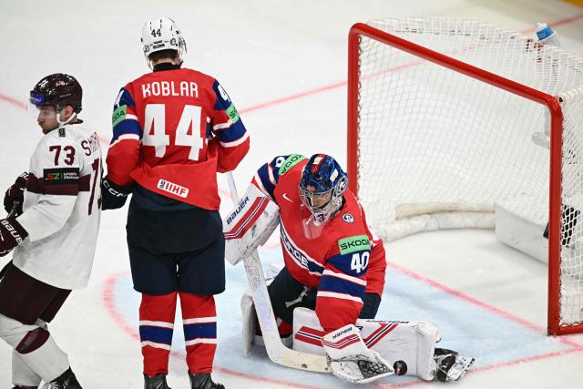 Norway's goalkeeper #40 Henrik Haukeland (R) saves the puck during the IIHF Ice Hockey Men's World Championship quarter-final match between Norway and Latvia in Fribourg, Switzerland on May 28, 2026. (Photo by Fabrice COFFRINI / AFP)