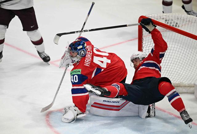 Norway's defender #43 Max Krogdahl (R) falls over Norway's goalkeeper #40 Henrik Haukeland during the IIHF Ice Hockey Men's World Championship quarter-final match between Norway and Latvia in Fribourg, Switzerland on May 28, 2026. (Photo by Fabrice COFFRINI / AFP)