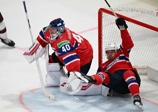 Norway's defender #43 Max Krogdahl (R) falls over Norway's goalkeeper #40 Henrik Haukeland during the IIHF Ice Hockey Men's World Championship quarter-final match between Norway and Latvia in Fribourg, Switzerland on May 28, 2026. (Photo by Fabrice COFFRINI / AFP)