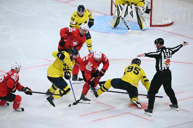 Sweden's defender #14 Mattias Ekholm (C-L) fights for the puck with Switzerland's forward #62 Denis Malgin (C) during the IIHF Ice Hockey Men's World Championship quarter-final match between Switzerland and Sweden at the Swiss Life Arena in Zurich, on May 28, 2026. (Photo by SEBASTIEN BOZON / AFP)