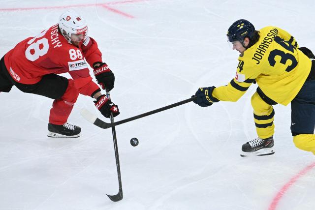 Switzerland's forward #88 Christoph Bertschy (L) fights for the puck with Sweden's defender #34 Albert Johansson during the IIHF Ice Hockey Men's World Championship quarter-final match between Switzerland and Sweden at the Swiss Life Arena in Zurich, on May 28, 2026. (Photo by SEBASTIEN BOZON / AFP)