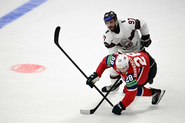 Latvia's forward #97 Haralds Egle (back) and Norway's forward #28 Michael Brandsegg-Nygard vie for the puck during the IIHF Ice Hockey Men's World Championship quarter-final match between Norway and Latvia in Fribourg, Switzerland on May 28, 2026. (Photo by Fabrice COFFRINI / AFP)