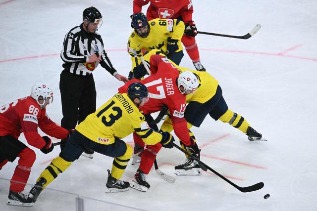 Sweden's forward #13 Lucas Raymond fights for the puck with Switzerland's forward #17 Ken Jager during the IIHF Ice Hockey Men's World Championship quarter-final match between Switzerland and Sweden at the Swiss Life Arena in Zurich, on May 28, 2026. (Photo by SEBASTIEN BOZON / AFP)