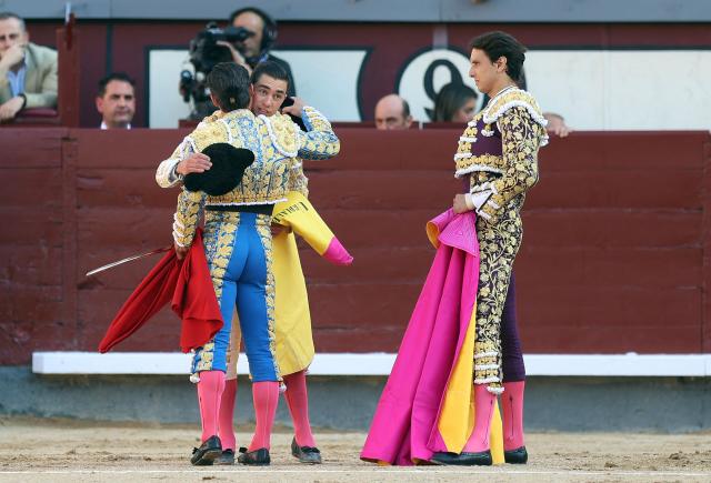 Mexican bullfighter Bruno Aloi (C) receives his "alternativa" —the ceremony by which a "novillero" (novice bullfighter) becomes a senior matador— from Spanish bullfighter Diego Urdiales (L), with Peruvian bullfighter Andres Roca Rey (R) acting as witness, during the San Isidro Fair at Las Ventas bullring in Madrid on May 28, 2026. (Photo by ALBERTO SIMON / AFP)
