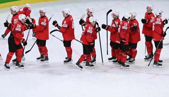 Switzerland's players congratulate each other after winning the IIHF Ice Hockey Men's World Championship quarter-final match between Switzerland and Sweden at the Swiss Life Arena in Zurich, on May 28, 2026. (Photo by SEBASTIEN BOZON / AFP)