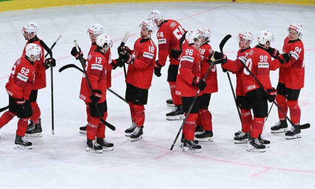Switzerland's players congratulate each other after winning the IIHF Ice Hockey Men's World Championship quarter-final match between Switzerland and Sweden at the Swiss Life Arena in Zurich, on May 28, 2026. (Photo by SEBASTIEN BOZON / AFP)