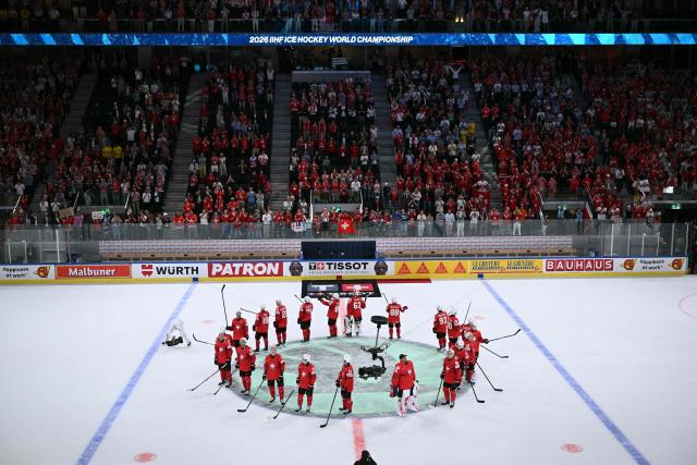 Switzerland's players celebrate after winning the IIHF Ice Hockey Men's World Championship quarter-final match between Switzerland and Sweden at the Swiss Life Arena in Zurich, on May 28, 2026. (Photo by SEBASTIEN BOZON / AFP)