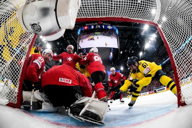 (From L) Sweden's forward #95 Jacob de la Rose, Switzerland's defender #90 Roman Josi, Switzerland's goalkeeper #63 Leonardo Genoni, Switzerland's forward #13 Nico Hischier, Sweden's forward #15 Jack Berglund, Switzerland's defender #86 Janis Moser, Switzerland's forward #62 Denis Malgin and Sweden's forward #61 Viggo Bjork fight for the puck during the IIHF Ice Hockey Men's World Championship quarter-final match between Switzerland and Sweden at the Swiss Life Arena in Zurich, on May 28, 2026. (Photo by CLAUDIO THOMA / POOL / AFP)