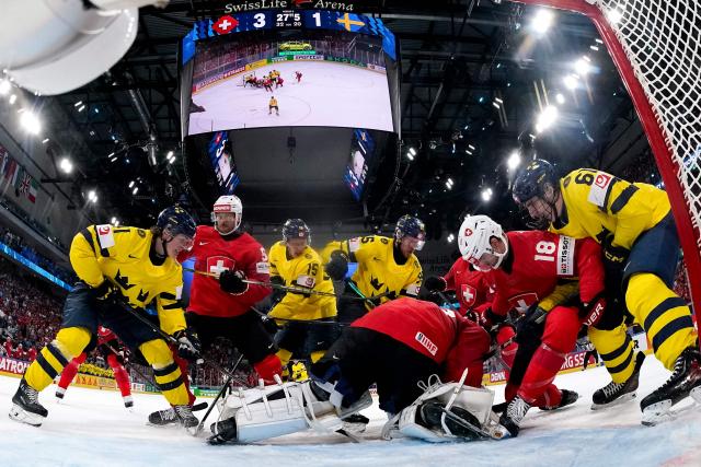 (From L) Sweden's forward #41 Ivar Stenberg, Switzerland's defender #54 Christian Marti, Sweden's forward #15 Jack Berglund, Sweden's forward #95 Jacob de la Rose, Switzerland's goalkeeper #63 Leonardo Genoni, Switzerland's defender #18 Sven Jung and Sweden's forward #61 Viggo Bjork fight for the puck during the IIHF Ice Hockey Men's World Championship quarter-final match between Switzerland and Sweden at the Swiss Life Arena in Zurich, on May 28, 2026. (Photo by CLAUDIO THOMA / POOL / AFP)