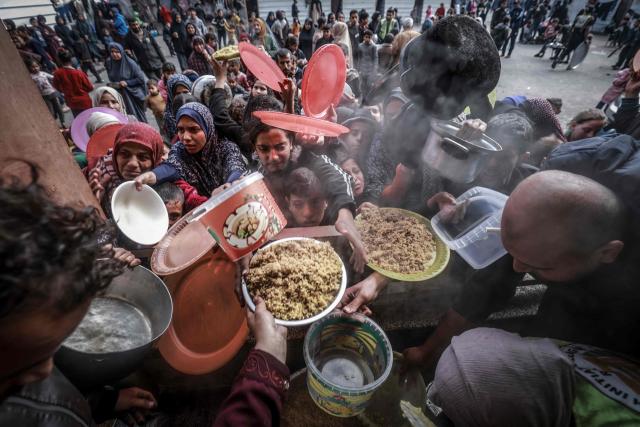 (FILES) Displaced Palestinians gather to receive food at a government school in Rafah in the southern Gaza Strip on February 19, 2024, amid the ongoing battles between Israel and the militant group Hamas. Professional photo and video journalists working in Gaza are to receive an annual press freedom award on June 1, 2026 for risking their lives to report on the war, an association of publishers has said. AFP photographer Mohammed Abed, who worked in Gaza until April 2024 before joining its Cairo bureau, will be among those at the ceremony in the French city of Marseille. (Photo by MOHAMMED ABED / AFP)