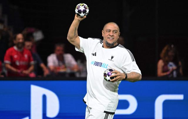 Roberto Carlos throws a ball as he arrives on the pitch prior to the Ultimate Champions Legends Tournament on May 29, 2026, at the Papp Laszlo Arena in Budapest, Hungary, on the eve of the UEFA Champions League final. (Photo by Attila KISBENEDEK / AFP)