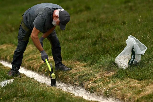 A volunteer works on the once-a-decade restoration of the Cerne Abbas Giant, in Dorchester, southern England on May 29, 2026. (Photo by Ben STANSALL / AFP)