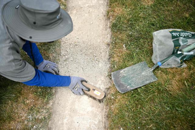A volunteer work on the once-a-decade restoration of the Cerne Abbas Giant, in Dorchester, southern England on May 29, 2026. (Photo by Ben STANSALL / AFP)