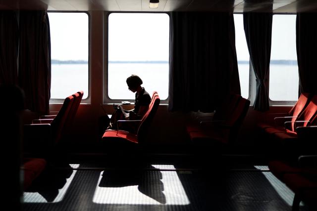 A passenger uses a laptop computer while traveling on a ferry connecting Le Verdon-sur-Mer (Gironde) to Royan (Charente-Maritime) during an anti-drug trafficking operation, off the coast of Royan, south-western France on May 29, 2026. (Photo by ROMAIN PERROCHEAU / AFP)