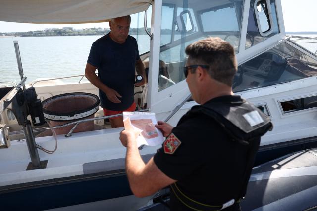 A French Maritime Gendarme conducts a check on a private boat off the coast of Royan, south-western France on May 29, 2026. (Photo by ROMAIN PERROCHEAU / AFP)
