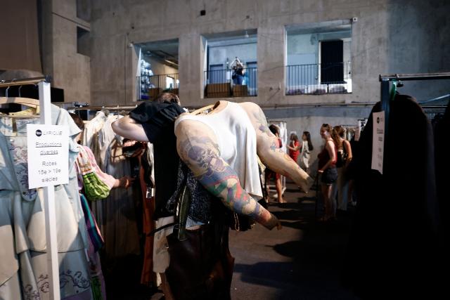Customers browse through items for sale during a costume sale held by the Bastille Opera in Paris on May 29, 2026. The Opera Bastille is putting around 5,000 costumes for sale. (Photo by Kenzo TRIBOUILLARD / AFP)